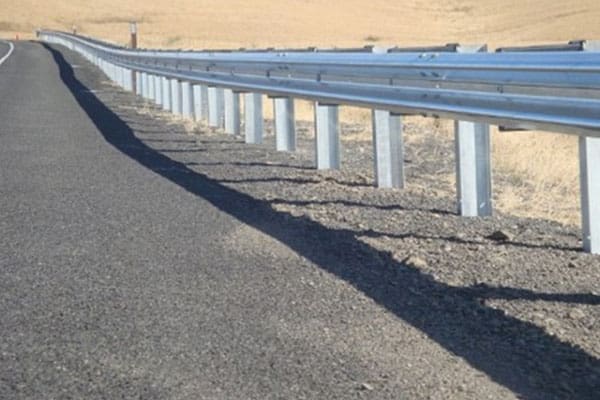 A road with some metal guardrails on it