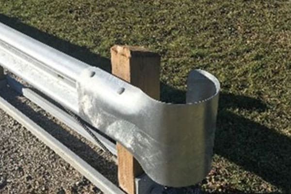 A metal fence post with some wood on top of it