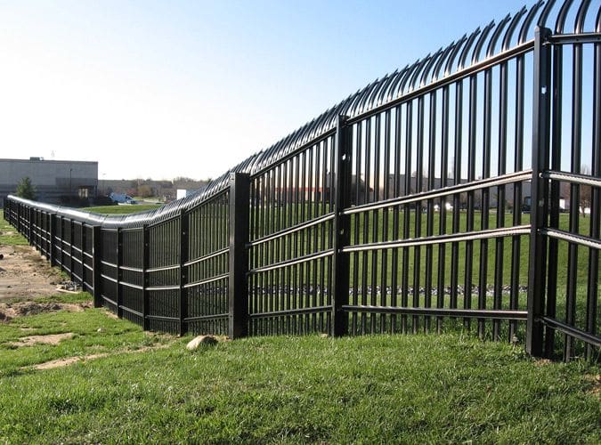 A fence that is made of metal and has a black top.