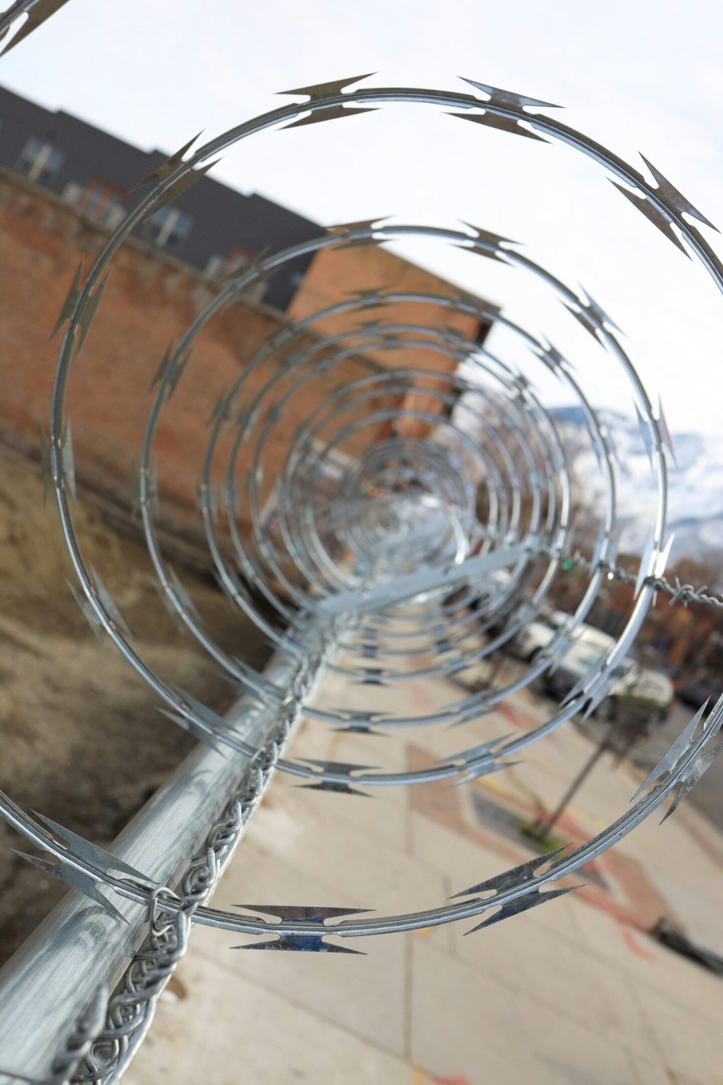 A close up of the razor wire on top of a pole.