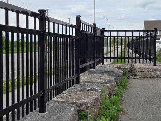 A fence with metal bars and stone steps.